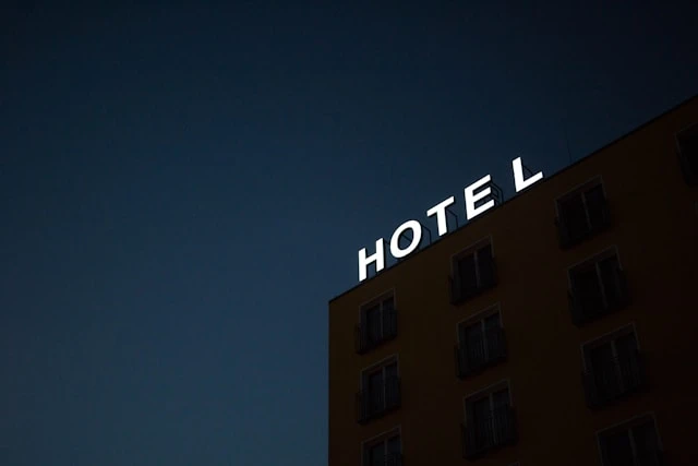 photo of Hotel lighted signage on top of brown building during nighttime