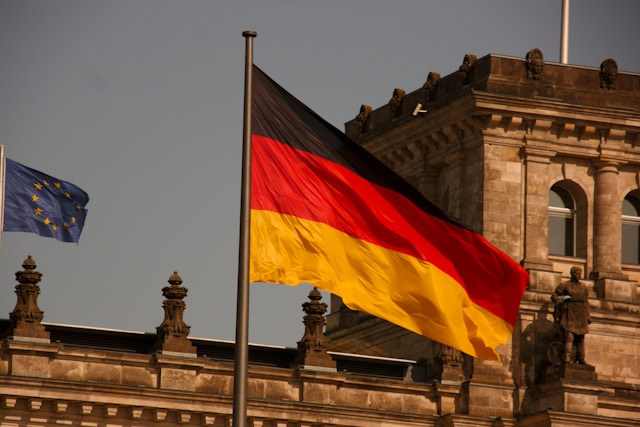 German flag waving in front of a historic stone building, suitable for illustrating the Consulate General of Germany in Kolkata